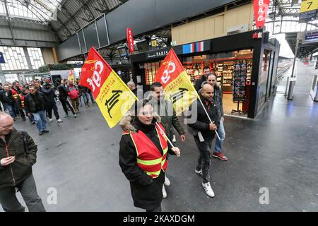 Demonstranten halten während einer Demonstration im Bahnhof Gare de L'Est am 3. April 2018 in Paris, am ersten Tag eines zweitägigen Streiks von Eisenbahnarbeitern, Gewerkschaftsflaggen fest. Die Mitarbeiter des staatlichen Eisenbahnunternehmens SNCF haben am 2. April um 7,00 Uhr (1700 Uhr GMT) den Job eingestellt, der erste in einer Reihe von Ausfällen, die alles von der Energie bis zur Müllabfuhr betreffen. Die bis zum 28. Juni andauenden Streiks auf der rollenden Schiene werden als die größte Herausforderung angesehen, die der Präsident noch vor den weitreichenden Plänen hatte, Frankreich aufzurütteln und seine Wettbewerbsfähigkeit zu stärken. (Foto von Michel Stoupak/NurPhoto) Stockfoto