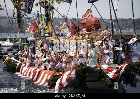 Eine Schiffsladung tanzender Fischer mit ihren weißen Gesichtern, die mit Frauenroben gekleidet waren, stand während des Ose Matiri/Festivals im Osezaki-Bezirk Numazu, Präfektur Shizuoka in Japan am 4. April 2018 im Mittelpunkt des Fischerhafens von Uchiura. Die festlichen Boote, die mit bunten Fahnen geschmückt waren, zogen den Hafen nach dem Weg zu einem nahe gelegenen Ose Jinja-Schrein, wo die Fischer Gebete für einen großen Fang und sicheres Segeln anboten. Die Fischer verkleiden sich traditionell während des Festes als Frauen, um sichere Ausflüge ins Meer und gute Fänge zu gewährleisten. Der Brauch soll von einer lokalen Folklore stammen Stockfoto