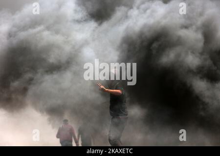 Palästinenser protestieren bei Zusammenstößen mit israelischen Oberkellern in der Nähe der Grenze zu Israel im Osten des Flüchtlingslagers Jabaliya im nördlichen Gazastreifen (06. April 2018, ausgestellt am 07. April 2018). Die palästinensische islamistische Gruppe Hamas rief am 06. April in der Nähe der Grenze zu Israel zu einem weiteren Protesttag auf, eine Woche nachdem 18 Palästinenser bei Zusammenstößen mit israelischen Streitkräften während eines marsches zur Grenze zum Gedenken an den jährlichen Landtag am 30. März getötet wurden. Die Demonstranten forderten, dass palästinensischen Flüchtlingen im Nahen Osten erlaubt werden sollte, in ihre angestammten Länder zurückzukehren, die derzeit israelischer Herkunft sind Stockfoto