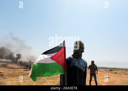 Palästinenser protestieren bei Zusammenstößen mit israelischen Oberkellern in der Nähe der Grenze zu Israel im Osten des Flüchtlingslagers Jabaliya im nördlichen Gazastreifen (06. April 2018, ausgestellt am 07. April 2018). Die palästinensische islamistische Gruppe Hamas rief am 06. April in der Nähe der Grenze zu Israel zu einem weiteren Protesttag auf, eine Woche nachdem 18 Palästinenser bei Zusammenstößen mit israelischen Streitkräften während eines marsches zur Grenze zum Gedenken an den jährlichen Landtag am 30. März getötet wurden. Die Demonstranten forderten, dass palästinensischen Flüchtlingen im Nahen Osten erlaubt werden sollte, in ihre angestammten Länder zurückzukehren, die derzeit israelischer Herkunft sind Stockfoto