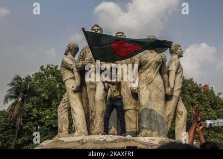 Während einer Demonstration der Studenten der Dhaka-Universität in Dhaka, Bangladesch, am 9. April 2018, gegen das Quotensystem, das bei der Rekrutierung von Regierungsstellen verwendet wird, protestiert ein Protestant mit einer bangladeschischen Flagge. Mindestens 100 Menschen wurden verletzt, als die Polizei mit Studenten zusammenprallte. (Foto von Khandaker Azizur Rahman Sumon/NurPhoto) Stockfoto