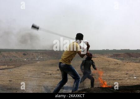 Ein palästinensischer Protestler wirft Steine bei Zusammenstößen nahe der Grenze mit Israel im Osten von Gaza-Stadt, 20. April 2018. Berichten zufolge wurden bei den Zusammenstößen in der Nähe der Grenze zwischen Israel und dem Gazastreifen zwei Jugendliche Demonstranten getötet und mehr als 120 weitere verletzt. Die Demonstranten wollen das Recht der palästinensischen Flüchtlinge im Nahen Osten auf Rückkehr in ihre Heimat fordern, die sie im Krieg um die Gründung Israels im Jahr 1948 geflohen sind. (Foto von Momen Faiz/NurPhoto) Stockfoto