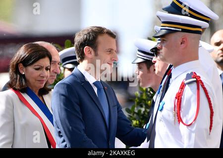 Der französische Präsident Emmanuel Macron schüttelt die Hände mit Polizisten, die von dem französischen Innenminister Gerard Collomb flankiert werden, während einer Zeremonie am 20. April 2018 in Gedenken an Xavier Jugele, einen französischen Polizisten, der vor einem Jahr bei einem Angriff auf der weltberühmten Avenue des Champs Elysees in Paris getötet wurde. (Foto von Julien Mattia/NurPhoto) Stockfoto