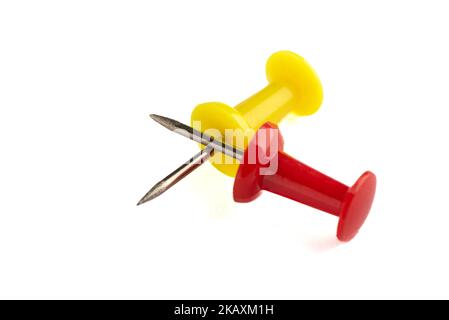 Nahaufnahme von gelben und roten Steckstiften auf weißem Hintergrund isoliert. Schreibwarenkonzept. Stockfoto