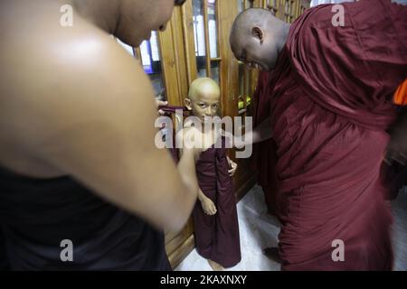 Ein neu ankommender buddhistischer Novizenmönch aus Sri Lanka wird während einer Zeremonie, die in Colombo zum Novizen buddhistischer Mönche (Samanera) geweiht wird, von hochrangigen buddhistischen Mönchen aus Sri Lanka in eine kastanienfarbene Robe gekleidet. Sri Lanka am Sonntag, den 29. April 2018, der auch den von Buddhisten gefeierten Vesak-Vollmondpoya-Tag anführt, um drei bedeutsame Ereignisse im Leben von Lord Buddha zu markieren – seine Geburt, Erleuchtung und sein Abschied von der menschlichen Welt. (Foto von Tharaka Basnayaka/NurPhoto) Stockfoto