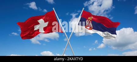 Zwei gekreuzte Flaggen Serbien und die Schweiz winken im Wind bei bewölktem Himmel. Konzept der Beziehung, des Dialogs, des Reisens zwischen zwei Ländern. 3D illustrat Stockfoto
