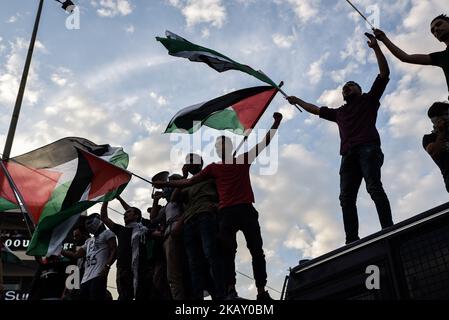 Palästinenser, die in Griechenland leben, schwenken während eines Protestes gegen das Blutvergießen entlang der Grenze zu Gaza und die Entscheidung der Vereinigten Staaten, die US-Botschaft am Dienstag, dem 15. Mai 2018, von Tel Aviv nach Jerusalem zu verlegen, palästinensische Fahnen an der Spitze des Polizeibusses. Hunderte von Demonstranten versammelten sich in Athen, um gegen die Entscheidung der USA, ihre Botschaft nach Jerusalem zu verlegen, zu protestieren und den Tod von 59 Palästinensern zu verurteilen, die am Montag bei einem massenmarsch an der Grenze zu Gaza durch israelische Schüsse getötet wurden. (Foto von Dimitris Lampropoulos/NurPhoto) Stockfoto