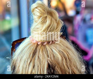 Blonde Haare auf einem Brötchen auf dem Kopf gebunden Stockfoto