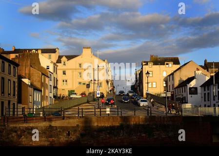 Eine Autobahn inmitten von Wohngebäuden bei Sonnenuntergang in der Küstenstadt Maryport, Cumbria, England Stockfoto