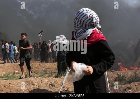 Dutzende von Tränengaskanistern, die von israelischen Truppen abgefeuert wurden, fallen über palästinensische Demonstranten an der Grenze zum Gazastreifen zu Israel, Freitag, 8. Juni 2018. Tausende Palästinenser strömen in Richtung des Zauns, der Gaza von Israel trennt, um gegen die jahrzehntelange Blockade ihres Territoriums zu protestieren, 8. Juni 2018 (Foto: Momen Faiz/NurPhoto) Stockfoto