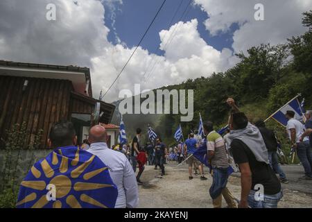 Demonstranten, die griechische Flaggen halten, stoßen bei einem Protest im Dorf Pisoderi nahe der Grenze zu Mazedonien in Nordgriechenland am 17. Juli 2018 auf die Bereitschaftspolizei, als die Außenminister Griechenlands und Mazedoniens eine historische vorläufige Vereinbarung über die Umbenennung Mazedoniens unterzeichneten. Die Außenminister Griechenlands und Mazedoniens unterzeichneten am 17. Juni ein historisches Vorabkommen, mit dem das kleine Balkanland in die Republik Nordmazedonien umbenannt werden soll, um einen 27-jährigen bilateralen Streit zu beenden. (Foto von N.E./NurPhoto) Stockfoto