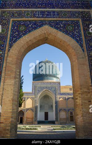 Blick auf das Wahrzeichen Gur e Amir, das Mausoleum von Timur oder Tamerlane durch das Eingangstor im zum UNESCO-Weltkulturerbe gehörenden Samarkand, Usbekistan Stockfoto