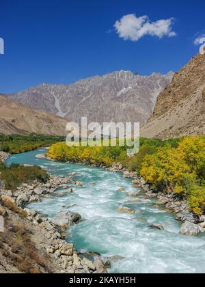 Farbenfrohe Landschaftsansicht des GUNT-Flusstals mit türkisblauem Wasser und goldenem Laub, Gorno-Badakshan, Tadschikistan Pamir Stockfoto