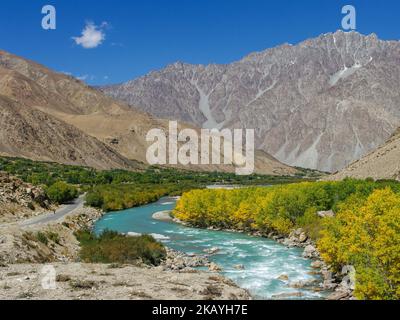 Herbstansicht der Berglandschaft des GUNT-Flusstals mit türkisblauem Wasser und goldenem Laub entlang des Pamir Highway, Gorno-Badakshan, Tadschikistan Stockfoto