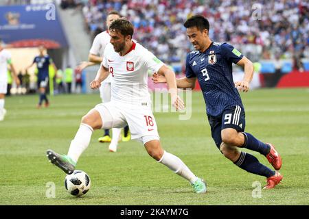 Batrosz Bereszynski aus Polen und Shinji Okazaki aus Japan kämpfen während des FIFA World Cup Group H-Spiels 2018 zwischen Japan und Polen in der Wolgograd Arena in Wolgograd, Russland, am 28. Juni 2018 um den Ball (Foto: Andrew Surma/NurPhoto) Stockfoto