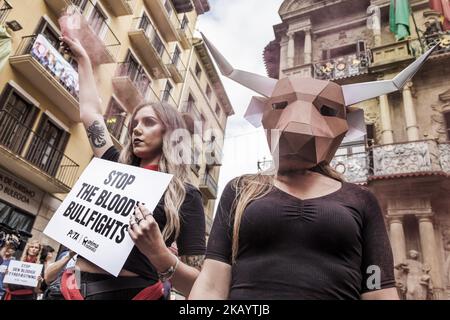 Der Aktivist gegen Tierquälerei bei Stierkämpfen trägt vor den Feierlichkeiten in San Fermin, Spanien, eine Stierkampfmaske aus Pappe. Auf dem Banner steht: „Stierkämpfer anhalten“. (Foto von Celestino Arce/NurPhoto) Stockfoto