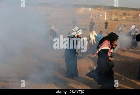 Demonstranten fliehen vor eintreffenden Tränengaskanistern, die von israelischen Streitkräften während einer Demonstration palästinensischer Frauen entlang der Grenze östlich von Gaza-Stadt am 3. Juli 2018 abgefeuert wurden. (Foto von Majdi Fathi/NurPhoto) Stockfoto