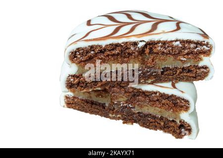 Nahaufnahme des traditionellen brasilianischen Honigkuchens mit halbierten weißen Schokoladenvereisungen, mit dulce de leche filling white Hintergrund. Stockfoto