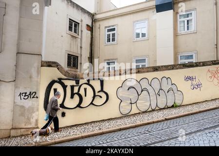 DOG WALKER, STEILHANG, LISSABON: Ein alter Mann geht mit seinem Hund einen steilen Hügel hinauf, Straßendetails Lissabon, Portugal, März 2022. Foto: Rob Watkins Stockfoto