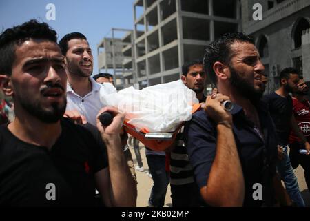 Verwandte und Trauernde tragen den Leichnam des 15-jährigen Palästinensers Amir al-Namira, der am 15. Juli 2018 bei einem israelischen Luftangriff bei seiner Beerdigung in einer Moschee in Gaza-Stadt, Gaza, getötet wurde. Im Alter von 15 und 16 Jahren befanden sich zwei Palästinenser auf einer Straße westlich von Gaza-Stadt, als ein Luftangriff auf ein nahegelegenes leeres Gebäude einschlug, teilte das Gesundheitsministerium der Enklave mit. Am 14. Juli entfesselte Israel eine Welle von Angriffen auf Gaza, während Dutzende von Raketen vom Territorium aus über die Grenze abgefeuert wurden. (Foto von Majdi Fathi/NurPhoto) Stockfoto