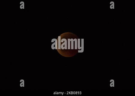 Der „Blutmond“ vor und während der Mondfinsternis im verwüsteten, aus dem Feuer stammenden Gebiet namens Mati in der Nähe von Athen. Das Schiff gehört der Küstenwache, da sie immer noch nach Menschen suchen. Die Finsternis ist die längste totale Mondfinsternis des Jahrhunderts, die einen Blutmond während eines Vollmondes zeigt 27. Juli 2018 - Mati, Attica - Griechenland (Foto von Nicolas Economou/NurPhoto) Stockfoto
