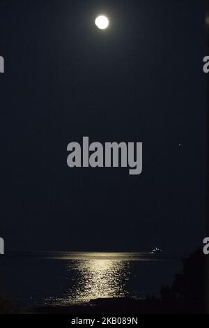 Der „Blutmond“ vor und während der Mondfinsternis im verwüsteten, aus dem Feuer stammenden Gebiet namens Mati in der Nähe von Athen. Das Schiff gehört der Küstenwache, da sie immer noch nach Menschen suchen. Die Finsternis ist die längste totale Mondfinsternis des Jahrhunderts, die einen Blutmond während eines Vollmondes zeigt 27. Juli 2018 - Mati, Attica - Griechenland (Foto von Nicolas Economou/NurPhoto) Stockfoto
