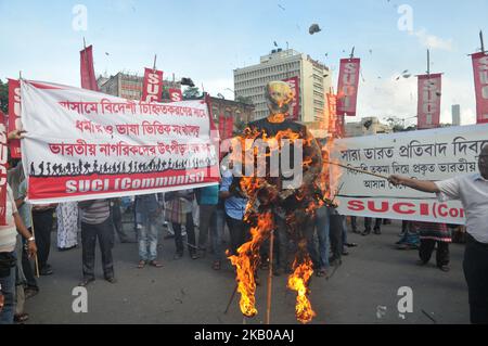 Das Socialist Unity Center of India (kommunistische) AKTIVISTEN DER POLITISCHEN Partei SUCI halten Plakate und verbrennen ein Bildnis des indischen Premierministers Narendra Modi während eines Protestes nach der Veröffentlichung eines Entwurfs des National Register of Citizens (NRC) am 08. August 2018 in Kalkutta. Indien hat am 30. Juli im nordöstlichen Bundesstaat Assam vier Millionen Menschen die Staatsbürgerschaft entzogen, was auf einen Listenentwurf zurückzuführen ist, der die Angst vor der Abschiebung weitgehend bengalischsprachiger Muslime ausgelöst hat. Kritiker sagen, dass es der jüngste Schritt des rechten Premierministers Narendra Modi ist, die Rechte der indischen Hindu-Mehrheit auf der zu fördern Stockfoto