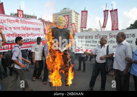 Das Socialist Unity Center of India (kommunistische) AKTIVISTEN DER POLITISCHEN Partei SUCI halten Plakate und verbrennen ein Bildnis des indischen Premierministers Narendra Modi während eines Protestes nach der Veröffentlichung eines Entwurfs des National Register of Citizens (NRC) am 08. August 2018 in Kalkutta. Indien hat am 30. Juli im nordöstlichen Bundesstaat Assam vier Millionen Menschen die Staatsbürgerschaft entzogen, was auf einen Listenentwurf zurückzuführen ist, der die Angst vor der Abschiebung weitgehend bengalischsprachiger Muslime ausgelöst hat. Kritiker sagen, dass es der jüngste Schritt des rechten Premierministers Narendra Modi ist, die Rechte der indischen Hindu-Mehrheit auf der zu fördern Stockfoto