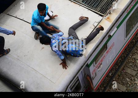 Menschen, die in Bangladesch leben, fahren auf dem Dach eines Zuges, während sie am 19. August 2018 in ihr Zuhause zurückkehren, um das Eid-Al-Adha-Festival in Dhaka, Bangladesch, zu feiern. Tausende von Dhaka-Stadtbewohnern begannen, die Stadt in die Heimatstadt zu verlassen, um das Eid-al-Adha-Festival zu feiern. (Foto von Mamunur Rashid/NurPhoto) Stockfoto