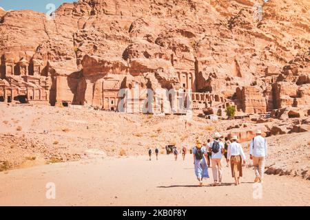 Gruppe von Freunden paar Touristen Spaziergang durch Höhlen von Gräbern in der alten Stadt Petra, Jordanien. Es ist bekannt als das Loculi. Petra hat zu seiner Bezeichnung als geführt Stockfoto