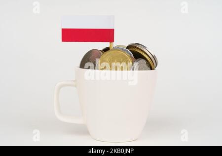 Die polnische Flagge ragt aus einem Becher mit Münzen hervor. Wirtschafts- und Geschäftskonzept. Stockfoto