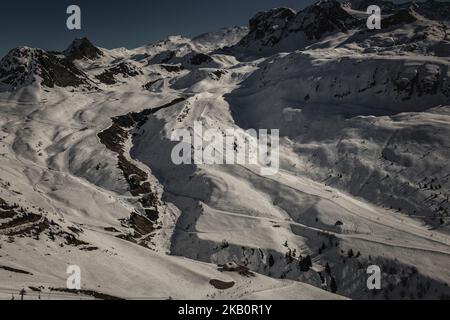 Hoch in den Bergen mit Blick über das Tal auf Skifahrer auf den Skipisten La Plagne Alpes Region Frankreich Stockfoto
