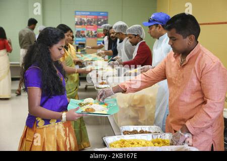 Das traditionelle Sadhya-Essen wird serviert, während Mitglieder der kanadischen Malayalee-Gemeinde eine Spendenaktion für die Opfer der Überschwemmungen in Kerala, Indien, veranstalteten. Die Spendenaktion fand am 15. September 2018 in Mississauga, Ontario, Kanada, statt und Hunderte kamen, um ihre Unterstützung zu geben. Durch heftige Regenfälle wurden mehr als 800.000 Menschen vertrieben und mehr als 373 Menschen bei der so genannten schlimmsten Überschwemmung in Kerala seit fast einem Jahrhundert getötet. Alle 14 Bezirke des Staates wurden in Alarmbereitschaft versetzt, und 35 der 42 Staudämme innerhalb des Staates wurden zum ersten Mal in der Geschichte eröffnet. (P Stockfoto