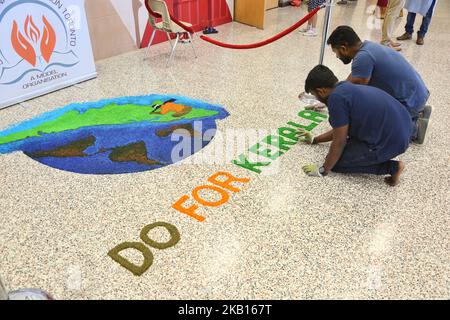 Jugendliche schaffen einen farbenfrohen Rrangoli (Rrangoli, auch bekannt als kolam, ist ein traditionelles Design, das mit farbigem Pulver auf den Boden gezogen wurde) mit den Worten „Do for Kerala“, da Mitglieder der kanadischen Malayalee-Gemeinschaft an einer Spendenaktion für die Opfer der Überschwemmungen in Kerala teilnehmen, Indien. Die Spendenaktion fand am 15. September 2018 in Mississauga, Ontario, Kanada, statt und Hunderte kamen, um ihre Unterstützung zu geben. Durch heftige Regenfälle wurden mehr als 800.000 Menschen vertrieben und mehr als 373 Menschen bei der so genannten schlimmsten Überschwemmung in Kerala seit fast einem Jahrhundert getötet. Alle 14 Bezirke der St Stockfoto