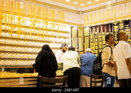 Dubai, VAE - 12.. oktober, 2022 : der Verkäufer verkauft Gold für arabische Kunden in seinem Geschäft im Gold-Souk im alten Dubai Stockfoto