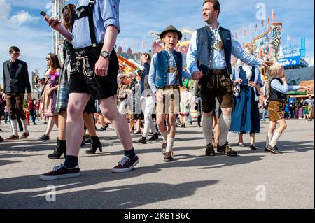 Tausende Besucher strömen nach der offiziellen Eingangsöffnung auf das Festivalgelände, um am ersten Tag des Oktoberfestes 2018 in München am 22. September 2018 die besten Plätze zu finden. Da das Oktoberfest das größte Bierfest der Welt ist und in der Regel über sechs Millionen Besucher während des dreiwöchigen Laufs anzieht, gaben die Behörden bekannt, dass sie für die Dauer der Veranstaltung verstärkte Sicherheitsmaßnahmen, einschließlich zusätzlicher polizeilicher Überwachung, in der Region einführen werden. Das Oktoberfest umfasst massive Bierzelte, die jeweils von einem anderen bayerischen Brauer betrieben werden, sowie Vergnügungsfahrten und ein Stockfoto