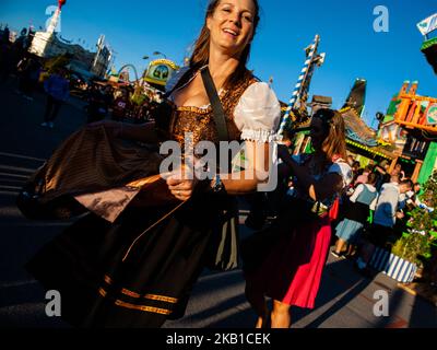 September 23., München. Nach der berühmten Kostüm- und Schützenparade setzen alle Besucher die Feier auf dem Oktoberfest fort. Das Oktoberfest ist das größte Bierfest der Welt und zieht in der Regel über sechs Millionen Besucher während des dreiwöchigen Laufs an. Das Oktoberfest umfasst riesige Bierzelte, die jeweils von einem anderen bayerischen Brauer betrieben werden, sowie Fahrgeschäfte und Aktivitäten. Das Oktoberfest findet in München statt, auf der berühmten Theresienwiese, die von den Einheimischen auch Festwiese genannt wird. Die großen Zelte werden im Sommer errichtet. Der Bau beginnt im Juni und dauert Stockfoto