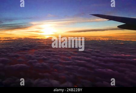 Sonnenuntergang über den Wolken mit Flugzeugflügel Stockfoto