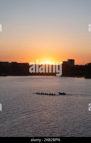 Farbenfrohe Silhouette des Ottawa River Ruderteams beim Sonnenuntergang. Stockfoto