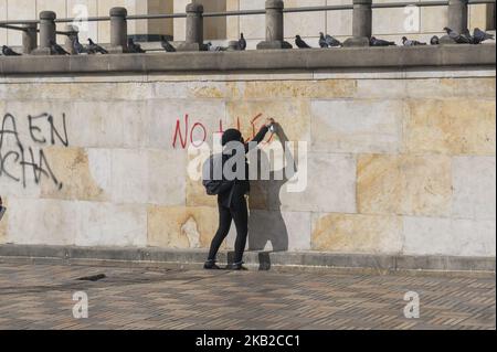 Eine Person mit Kapuze, die am 23. Oktober 2018 ein Graffiti über den studentenmarsch auf der Plaza de Bolívar, Bogota, Kolumbien, schrieb. (Foto von Daniel Garzon Herazo/NurPhoto) Stockfoto