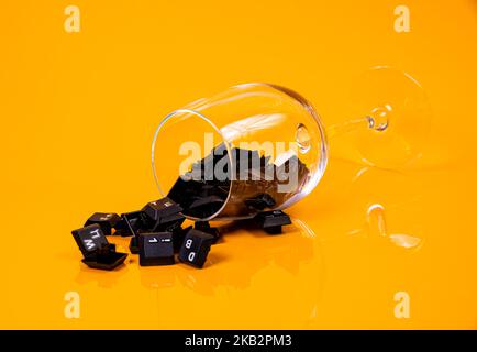 Tastatur-Taste in Glas in Eimer auf orangefarbenem Hintergrund isoliert Hacker Stockfoto