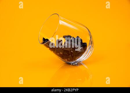 Tastatur-Taste in Glas in Eimer auf orangefarbenem Hintergrund isoliert Hacker Stockfoto