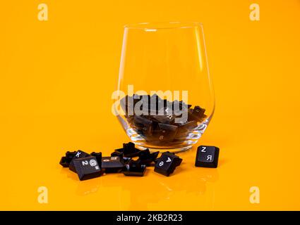 Tastatur-Taste in Glas in Eimer auf orangefarbenem Hintergrund isoliert Hacker Stockfoto