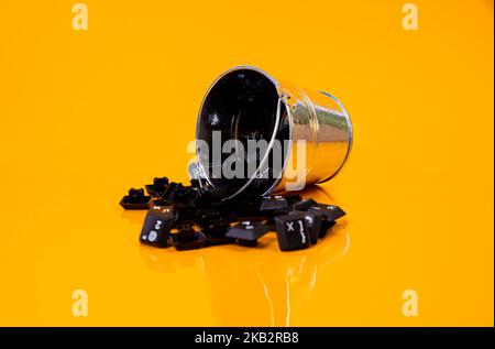 Tastatur-Taste in Glas in Eimer auf orangefarbenem Hintergrund isoliert Hacker Stockfoto