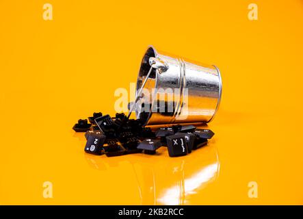 Tastatur-Taste in Glas in Eimer auf orangefarbenem Hintergrund isoliert Hacker Stockfoto