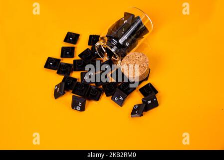 Tastatur-Taste in Glas in Eimer auf orangefarbenem Hintergrund isoliert Hacker Stockfoto