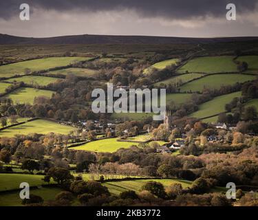 Widecombe-in-the-Moor, Dartmoor-Nationalpark, Devon, Großbritannien. 3.. November 2022. UK Wetter: Dartmoor ist an einem herbstlichen Tag voller Sonnenschein und Schauern in einer herrlichen Farbe erstrahlend. Abgebildet ist das Dorf Widecombe-in-the-Moor mit dem markanten Turm der St. Pancras Kirche, der im Sonnenschein beleuchtet ist. Das Dorf liegt mitten in Dartmoor und ist von wildem Moor umgeben. Kredit: Celia McMahon/Alamy Live Nachrichten Stockfoto