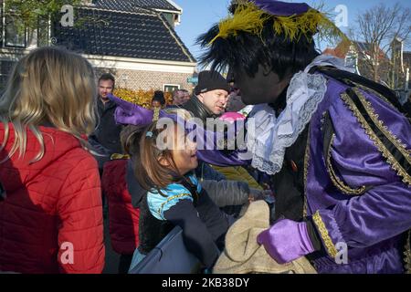 Am 17. November 2018 nahmen mehrere Personen an der Veranstaltung Teil, die als Zwarte Piet. In Zaandam, Niederlande, getarnt waren. Der heilige Nikolaus kommt noch ein Jahr von Spanien nach Holland. Dieses Jahr wurde dieses Fest in der Stadt Zaandam, die für ihre malerischen Windmühlen berühmt ist, landesweit gefeiert. Von dort aus wird der Nikolaus in die übrigen niederländischen Städte fahren. Wieder einmal wurde die Feier von der Kontroverse beeinflusst, die von antirassistischen Gruppen geschaffen wurde, die diese Tradition des Habens rassistischer Komponenten beschuldigen. Insbesondere in der Figur von Zwarte Piet, einer Figur, die als schwarzes M erscheint Stockfoto