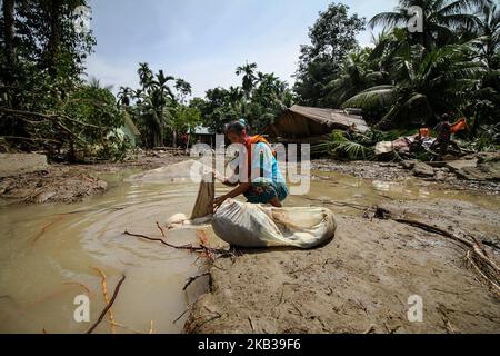 Eine Frau wurde gesehen, wie sie Trümmer aus einem Haus sammelte, das nach einer Überschwemmung beschädigt wurde, die durch Schäden an einem Flussufer nach heftigen Regenfällen in Nord-Aceh am 18. November 2018 in Aceh, Indonesien, verursacht wurde. (Foto von Fachrul Reza/NurPhoto) Stockfoto