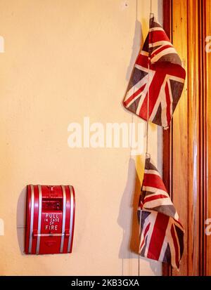 Union Jacks an einer Wand, Feueralarm, „Pull in case of Fire“; Craigdarroch Castle, Victoria, B.C., Kanada Stockfoto